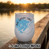 A white insulated tumbler featuring a blue map of Big Sandy Lake, Minnesota sits on a wooden dock at sunset.