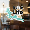 "Rainy Life" text sticker with turquoise lake outline on glass.