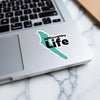 Teal sticker with "Willoughby Life" text on a laptop keyboard.