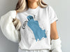 White t-shirt with text Cain Lake and a blue map outline of Washington State.