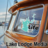 Turquoise lake map sticker with "Pleasant Life" text on a boat window above "Lake Lodge Media" text.