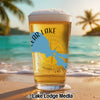 Beer glass with "Clear Lake California" map on beach with ocean and palm trees.