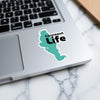Teal Connecticut shape sticker with "Conneaut Life" text on laptop keyboard.