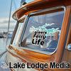 Greers Ferry Life sticker on a wooden boat window, with Lake Lodge Media text below.
