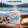 White mug with "Diamond Valley Lake California" design next to an open book.