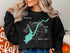 Black sweatshirt with turquoise outline of Sacandaga Lake and compass rose graphic.