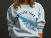 Light blue sweatshirt on model with Grapevine Lake map and compass graphic