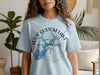 Light blue t-shirt with compass design featuring custom lake outline and text.
