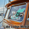 Turquoise 'Snow Life' sticker on a boat window with "Lake Lodge Media" text below.