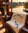 Blanket with Lake Wateree map and compass on brown leather sofa.