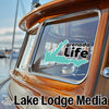 Teal map graphic with "grenada Life" text on a boat window. "Lake Lodge Media" text below.