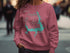 Pink sweatshirt with Lake Thunderbird Oklahoma map and compass graphic.