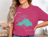 Pink t-shirt with a teal map of Lake Superior and compass graphic.