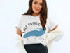 White t-shirt featuring a blue Lake Ontario map graphic with compass and text.