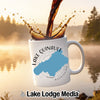 White mug with Lake Quinault map and compass, coffee splashing into it.