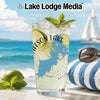 Tall glass of lemonade with lime and mint on a beach with sailboat.