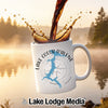 White mug with Lake Coeur d'Alene map and compass design, coffee splashing.