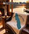 Woven blanket with "Onondaga Lake New York" and compass design on a couch.