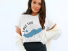 White t-shirt with blue Lake Erie map outline and compass graphic, plus "OHIO".