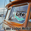 Turquoise outline of Sanibel island with "Sanibel Life" text on boat window.