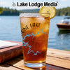 Glass of iced tea with "Lone Lake" text and compass design, lake background.