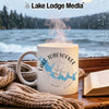 White mug with Lake Tobesofkee and compass design, by a window.