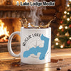 White mug with "Augur Lake New York" design and splash of coffee.