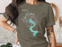 Olive t-shirt with turquoise Lake Whitney Texas map and compass graphic.