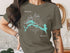 T-shirt featuring a turquoise map of Flagstaff Lake, Maine, with a compass rose.