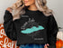 Black sweatshirt with "Dream Lake Colorado" map and compass graphic.