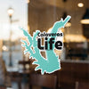 Turquoise Calaveras Life sticker on glass with blurred background.