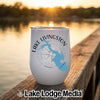 A white insulated wine tumbler featuring a blue map of Lake Livingston sits on a wooden dock at sunset.
