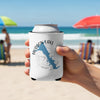 White can cooler with Hudson Lake Oklahoma map and compass design held on beach.
