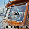 Windermere Life graphic on yacht window above Lake Lodge Media text.