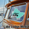 Teal Calhoun Life sticker on a wooden boat window, Lake Lodge Media logo below.