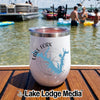 A white travel tumbler featuring Lake Fork Texas graphics sits on a boat deck overlooking a lake with people swimming.