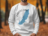 White sweatshirt with a blue Carlyle Lake map and compass graphic.