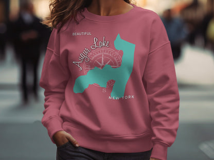 Pink sweatshirt with blue outline of Lake George and compass graphic.