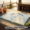 A glass cutting board featuring a Lake Okanagan compass map design sits on a wooden dock.