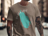 Brown t-shirt with a turquoise outline of a lake and compass rose graphic that says "Black Lake New York".