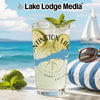 Glass of lemonade with lime and mint on a beach, "Lake Lodge Media" text.