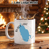 White mug with Black Lake New York map and compass design, steam rising from coffee.