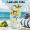 Glass with drink, limes, mint, and "Weiss Lake" logo on beach background.