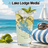 Glass with drink, lime, mint, and "Lake Winnipesauke" design on beach.