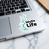 Wylie Life sticker with turquoise lake outline on laptop.
