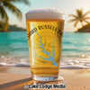 Glass of beer on a beach with Lake Russell Georgia design and palm trees.