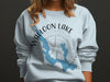 Light blue sweatshirt with a Waloon Lake map and compass graphic.