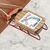 Wooden sled ornament with "Merry Christmas FROM Eklutna Lake" text.