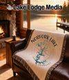 Woven throw blanket with Norfork Lake Arkansas map design on a couch.