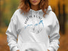 White hoodie with Fort Peck Lake Montana compass and map graphic.